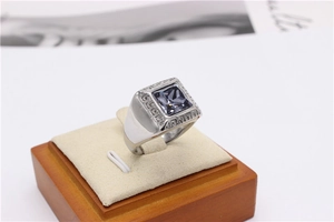 Macro shot of silver titanium steel ring with square grey stone and Greek meander engraving