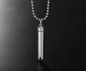 Detailed view of polished stainless steel bullet pendant and round bead chain necklace