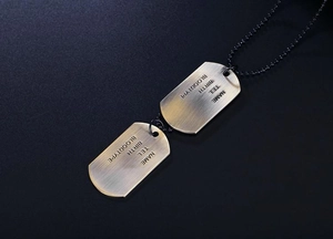 Close-up of vintage brass dog tags with brushed metal texture and custom engraving detail