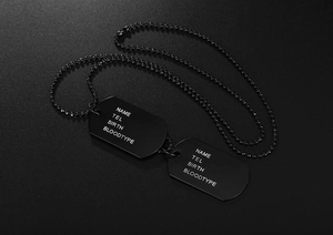 Detail of matte black military dog tags with custom name and blood type engraving