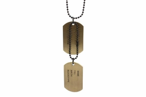 Close-up of dual vintage dog tags with engraved identity info on black bead chain