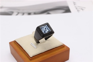 Detail of black titanium ring with square blue gemstone and Greek key relief pattern