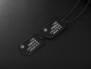 Detail view of matte black U.S. Army dog tag necklace with engraved Rambo text
