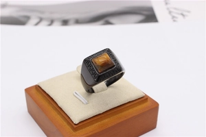 Detail of black titanium ring featuring a square tiger eye stone and Greek fret carvings