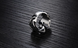 Gros plan sur une bague vintage en forme de griffe de dragon argentée aux détails punk