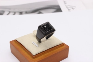 Close-up of black signet ring featuring square black gemstone and Greek Key side patterns