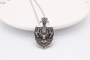 Close-up of vintage silver shield necklace with elk head and viking compass symbols