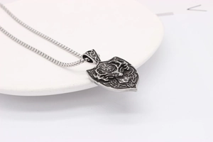 Close-up of vintage silver shield pendant with viking elk deer head and compass runes