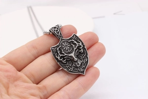 Close-up of vintage steel shield pendant with reindeer and Vegvisir compass engraving