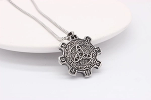 Detailed view of silver Viking Triquetra pendant with Nordic Runes on a box chain