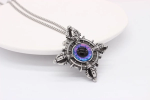 Macro detail of gothic cross pendant with a purple evil eye bead and steel chain