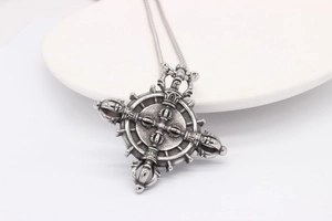 Macro view of retro stainless steel Dharma Wheel pendant with intricate Vajra carvings