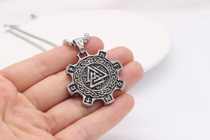 Macro detail of Nordic Valknut pendant with Viking runes and vintage steel chain