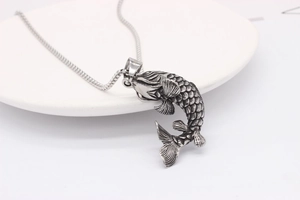 Macro shot of vintage silver koi fish pendant with realistic scales and detailed metal fins