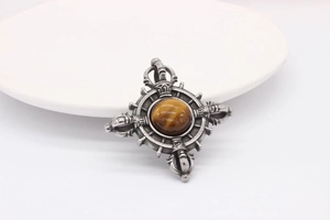 Macro detail of vintage steel pendant with tiger eye stone and vajra carving