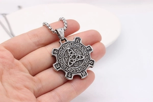 Close-up of vintage Viking pendant with Triquetra knot and Nordic runes details