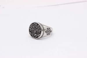 Macro detail of retro stainless steel signet ring with Tree of Life and Celtic knot motifs