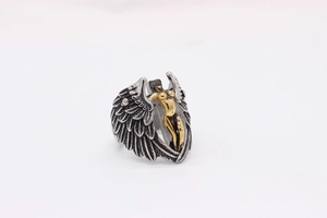 Detailed macro view of silver angel wings and gold female figure on gothic ring