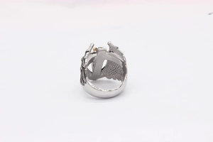 Macro detail of silver eagle wings ring with golden sphere in retro punk style