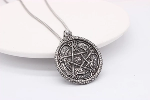 Close-up of vintage steel Viking pendant featuring a pentagram and Celtic knot details