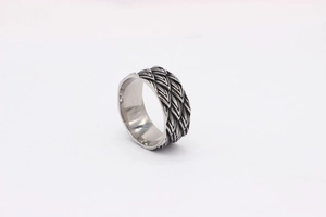 Macro detail of retro dragon scale relief and polished inner band on titanium steel ring