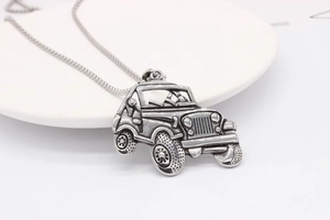 Macro shot of retro off-road jeep pendant with detailed grille and rugged tires on chain