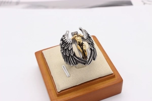Macro shot of retro gothic angel ring showing intricate wings and gold figure details