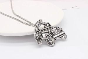 Macro shot of vintage silver off-road jeep pendant with intricate 3D industrial details