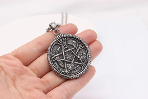 Macro detail of vintage Viking star pendant with silver oxidation and woven textures