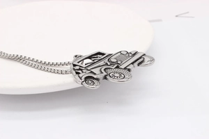 Detailed view of vintage off-road car pendant with intricate metallic grille and square chain