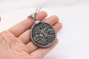 Macro detail of vintage Viking Tree of Life steel pendant on cross chain necklace