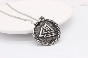 Macro view of vintage silver Valknut pendant with intricate braided edge and metal chain