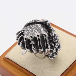 Vintage punk handshake ring for men in antique finish steel on a wooden stand