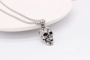 Macro detail of gothic skull pendant in silver steel on a sturdy square box chain
