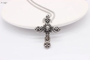 Gothic retro skull cross pendant necklace with iris motifs on a white plate