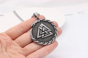 Macro view of Viking Valknut pendant with Ouroboros symbol in antique silver finish