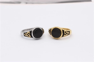 Detailed close-up of gold and silver Viking rings with black stones and Celtic knots