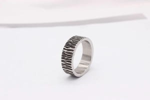 Macro view of men's stainless steel ring showing bark texture and polished inner band