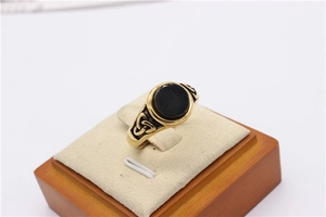 Detail view of gold Viking ring featuring black stone and Celtic knot engraving
