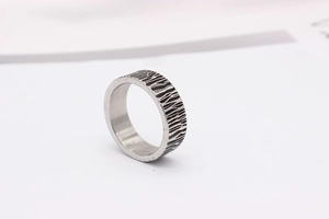 Macro detail of men's titanium steel ring featuring vintage bark texture and dark oxidized grooves