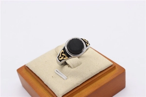 Detail of vintage Viking ring with black stone and golden Celtic knot on steel band