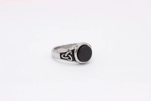 Macro detail of vintage steel ring featuring black onyx stone and Celtic knot engravings