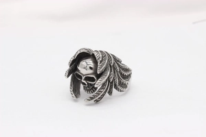 Detailed close-up of retro silver skull ring with gothic wing texture and punk style