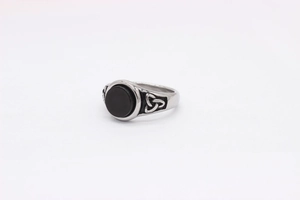 Detail of vintage steel ring with black stone and engraved Celtic triquetra symbols