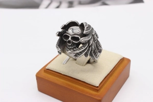 Macro shot of retro stainless steel skull ring with detailed feather wings and antique finish