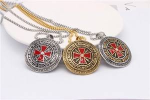 Detailed macro view of vintage cross shield pendants with red enamel on a box chain