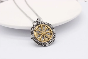 Détail macro du pendentif boussole Vegvisir viking avec reliefs floraux argentés