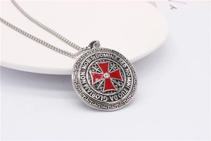 Detailed close-up of retro cross shield pendant with red enamel and Latin engraving