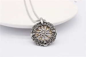Détail macro du pendentif boussole viking bicolore avec soleil doré et chaîne serpent de style vintage