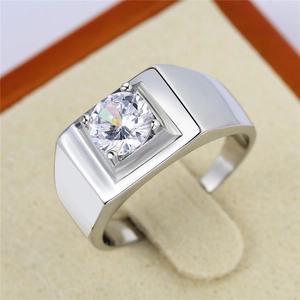 Macro shot of men's wedding ring featuring a brilliant solitaire stone and silver band